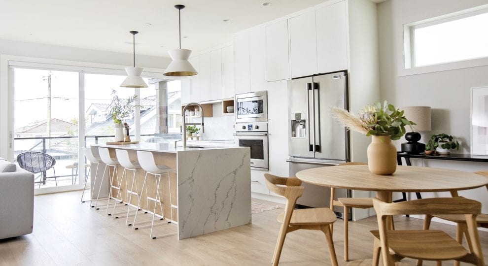 a bright and airy kitchen with a waterfall island and stainless steel appliances